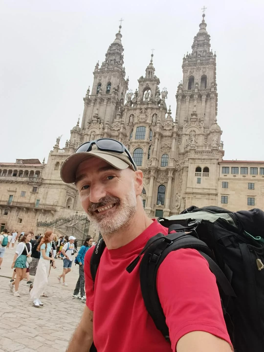 Carlos, di el.peregrino.digital, con lo zaino davanti alla cattedrale di Santiago de Compostela.
